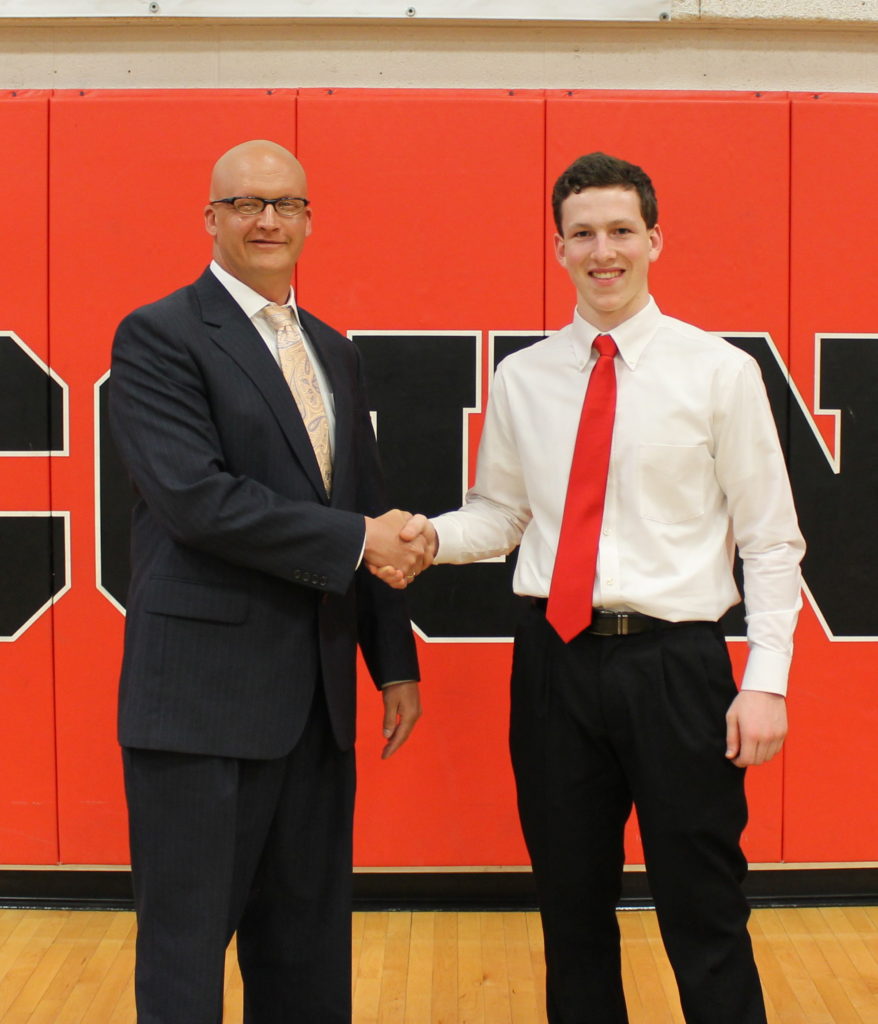 Nicholas Ruetter from the Farmers-Merchants National Bank presents Jeremy Steidinger with the 2018 FMNB scholarship.